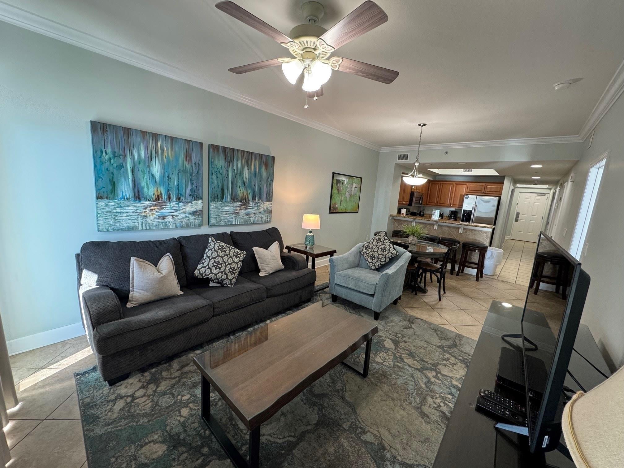Image 2: Tiled living room with ceiling fan and ornamental molding