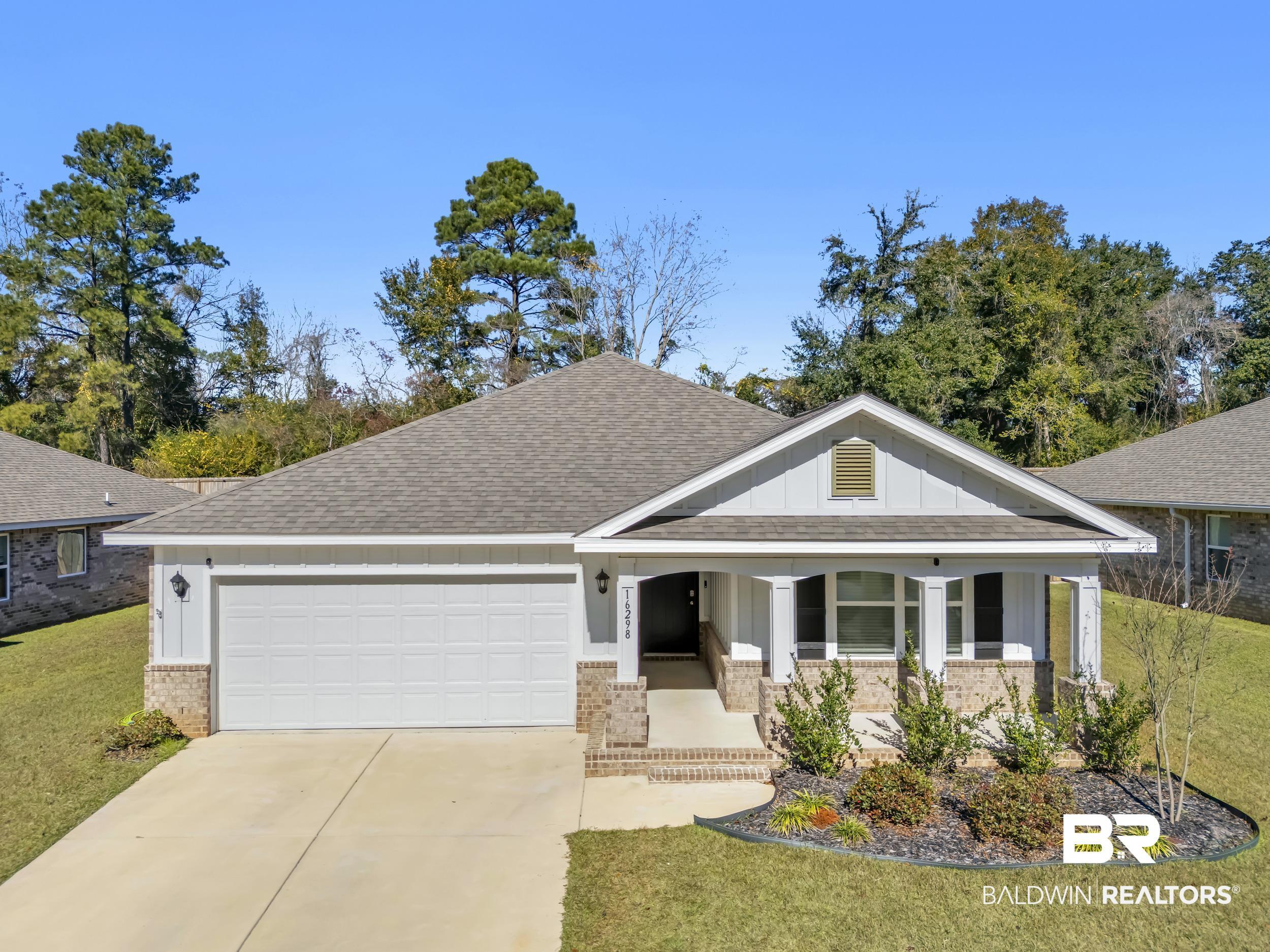 Image 1: Craftsman house with brick siding, board and batten siding, a shingled roof, a porch, and concrete driveway