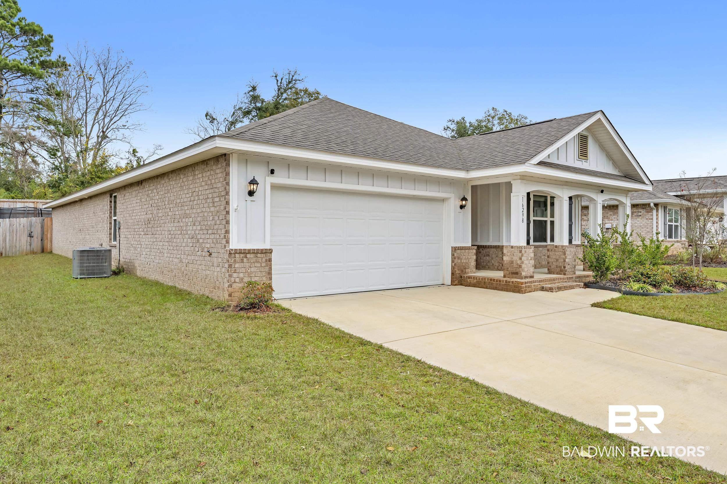 Image 3: View of front of house featuring brick siding, a porch, a shingled roof, and a front lawn