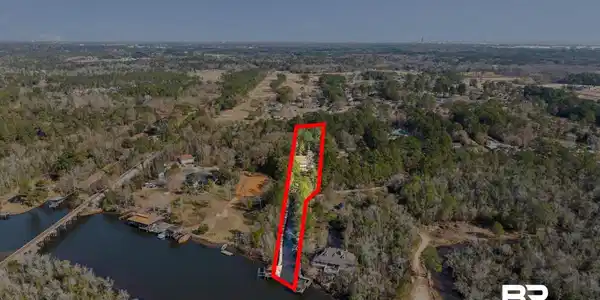 Image 3: Aerial view of property's location with property parcel outlined and a large body of water