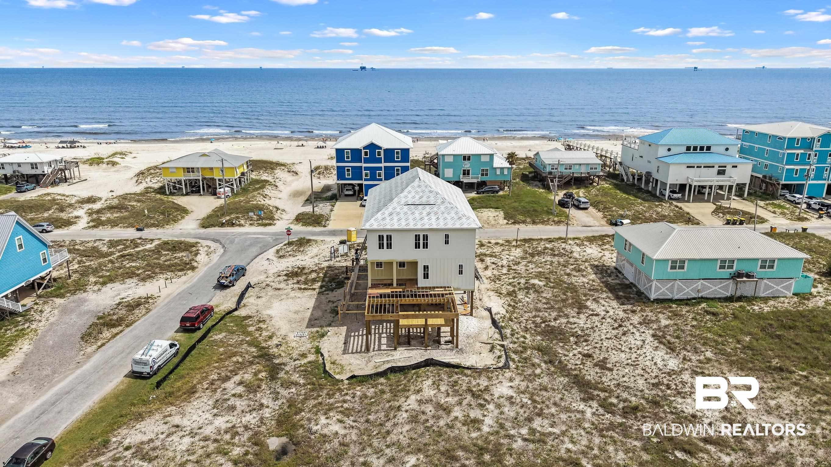 Image 4: Elevated coastal residence featuring white siding and a light-colored roof