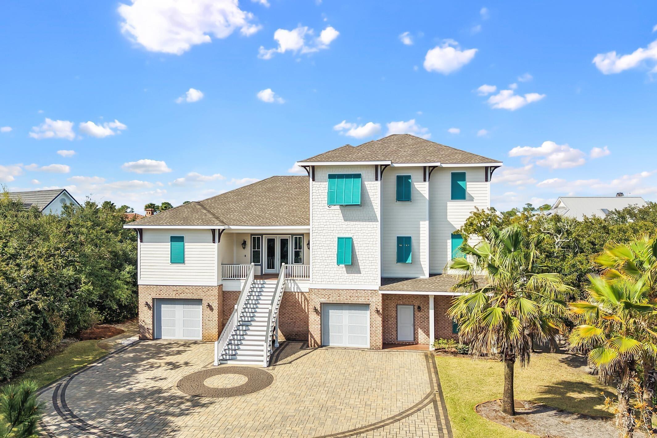 Image 2: Coastal home with roof with shingles, a balcony, decorative driveway, an attached garage, and brick siding