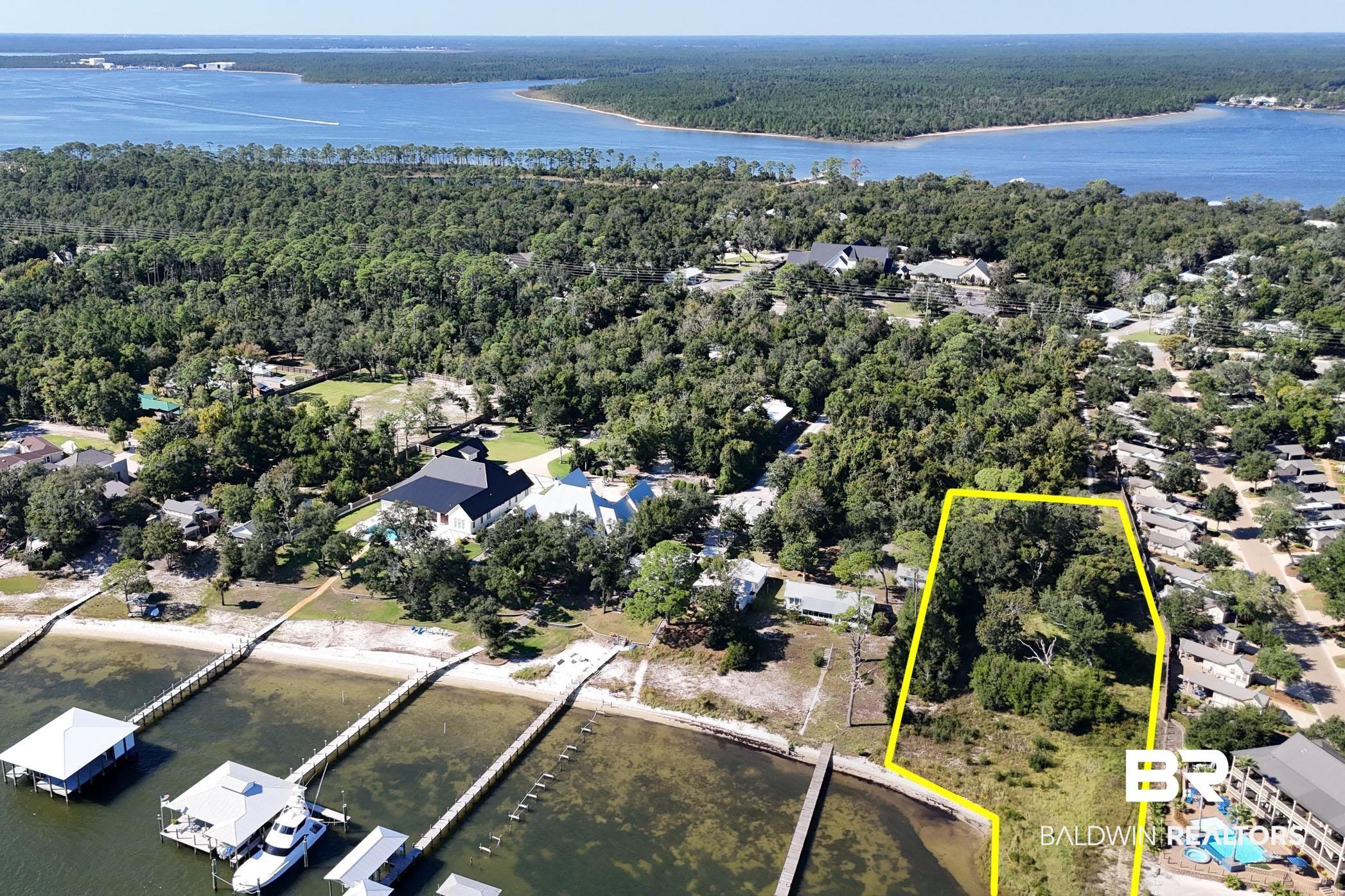 Image 2: Aerial view of property and surrounding area featuring a nearby body of water and property parcel outlined