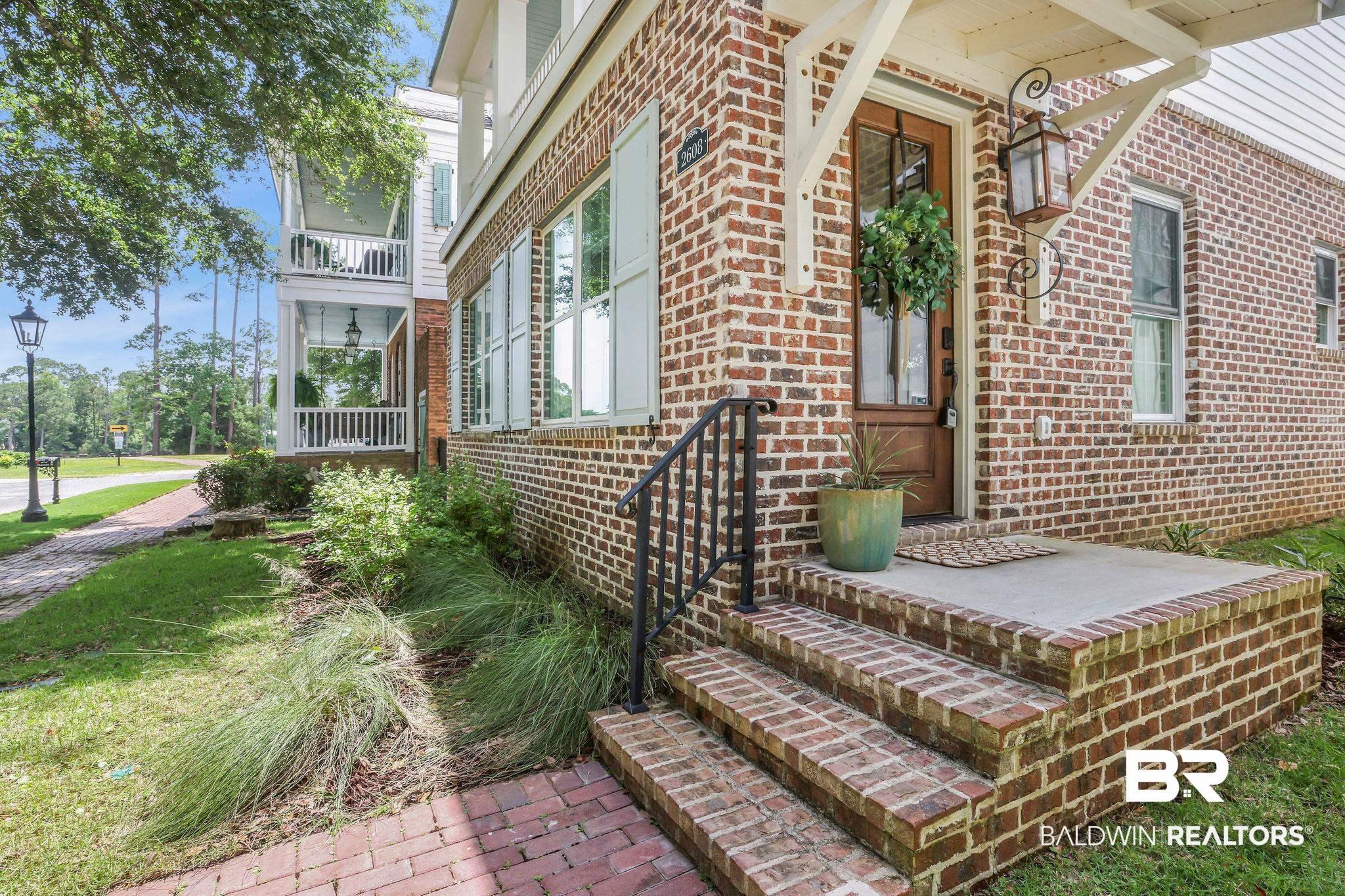 Image 2: View of exterior entry featuring brick siding