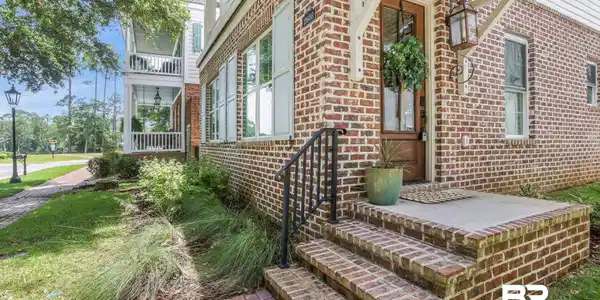 Image 2: View of exterior entry featuring brick siding
