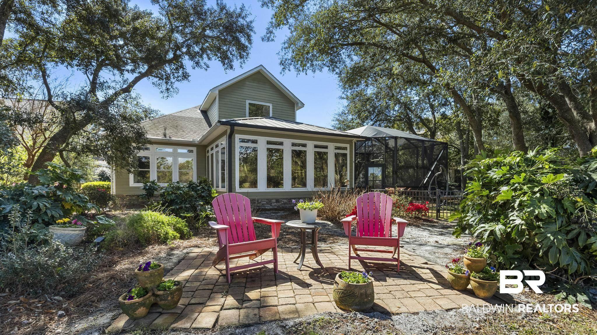Image 3: Rear view of house with a sunroom, a patio, a lanai, and roof with shingles