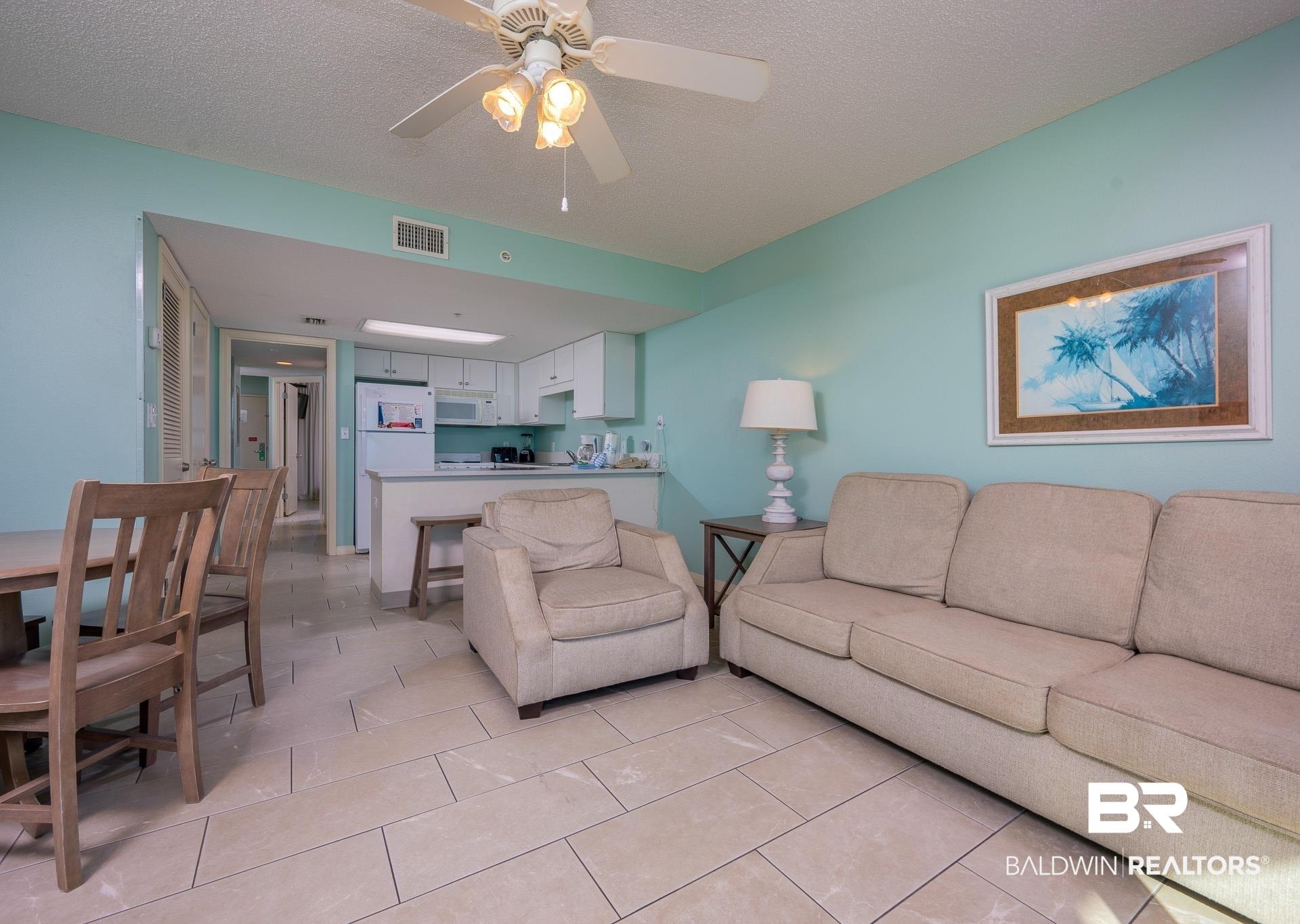 Image 4: Living area with ceiling fan and a textured ceiling