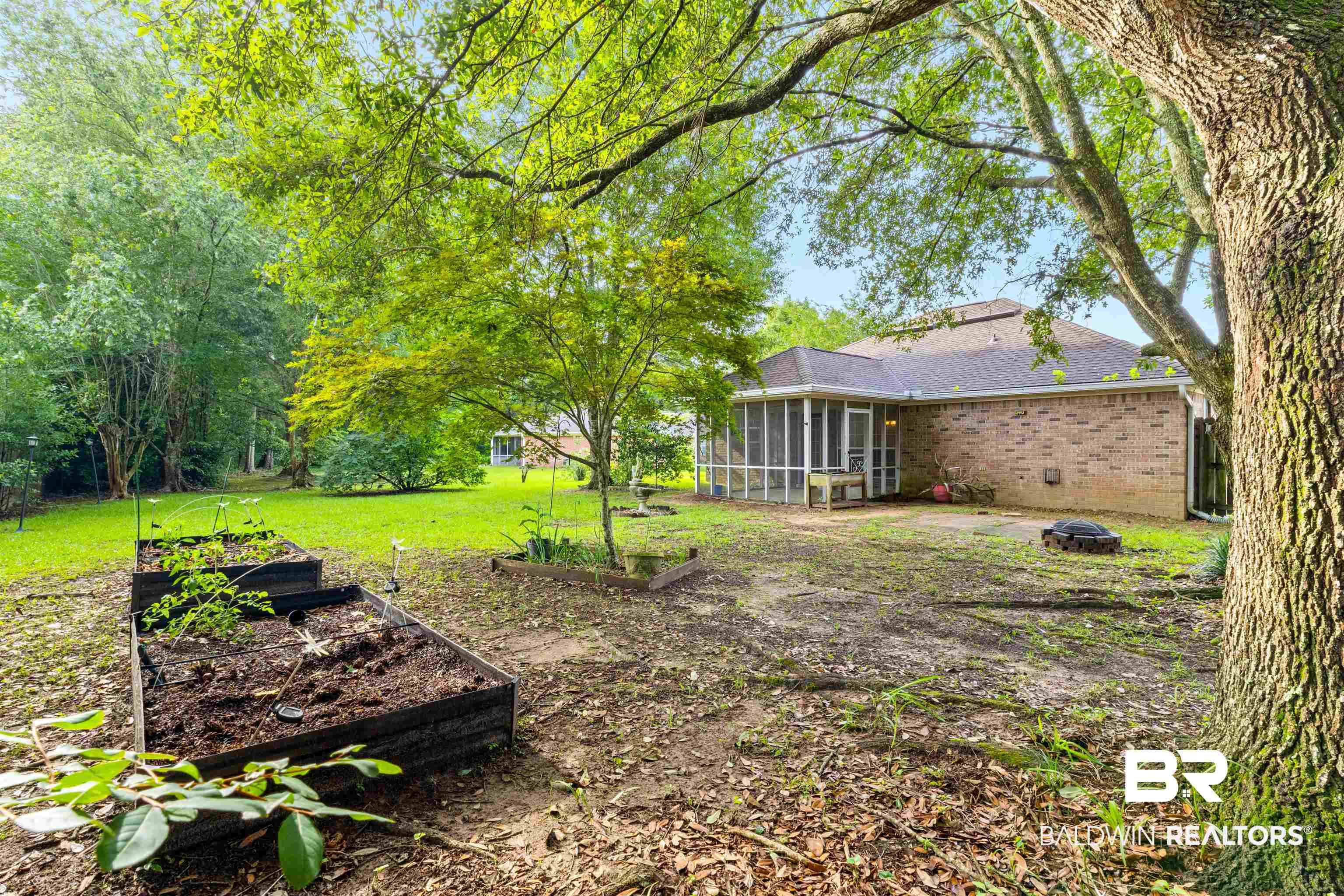 Image 3: Expansive backyard featuring a screened porch, brick exterior, and mature trees