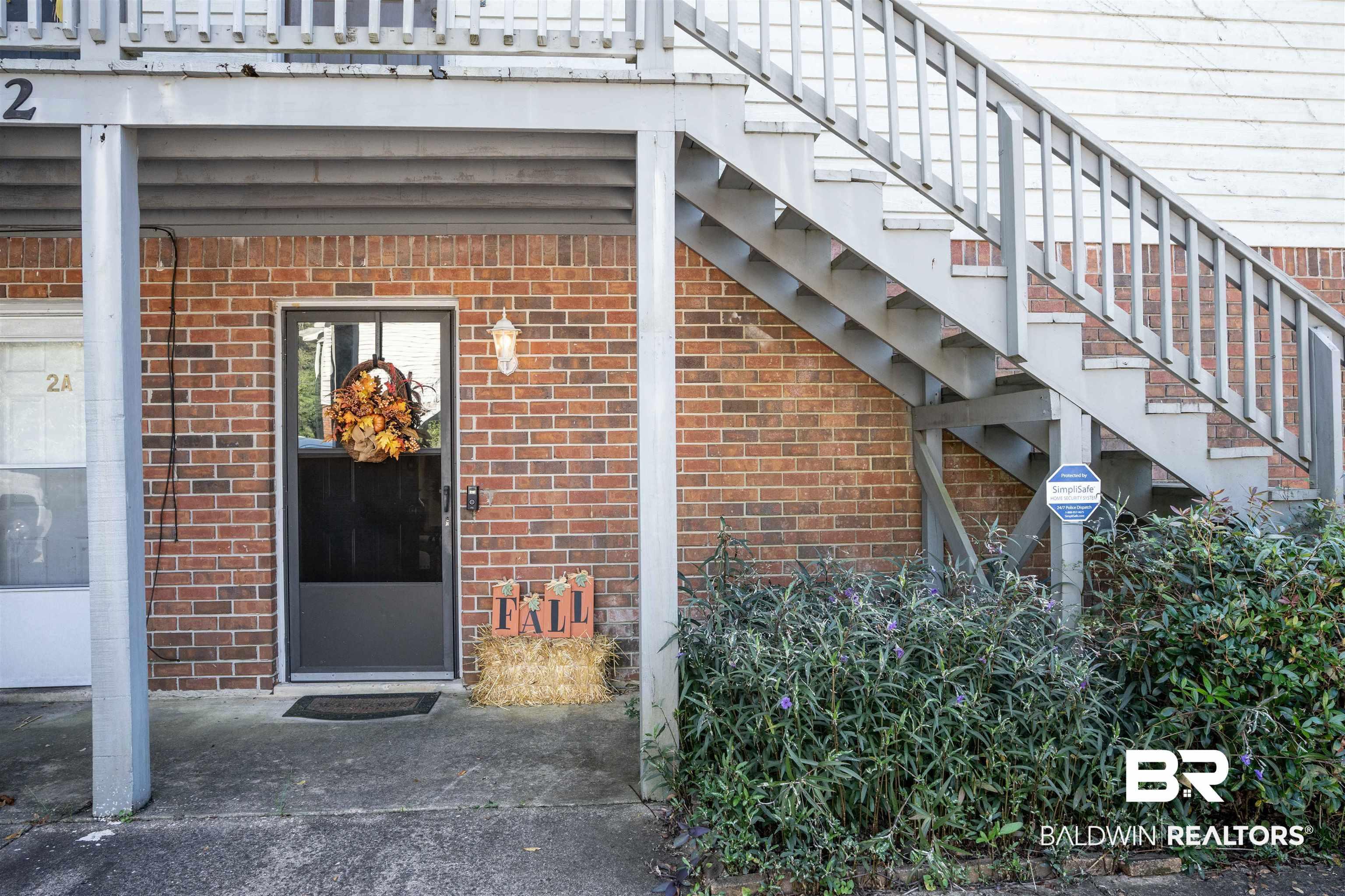 Image 2: Property entrance with brick siding