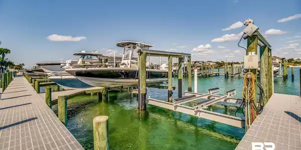 Image 3: Dock featuring boat lift and a water view