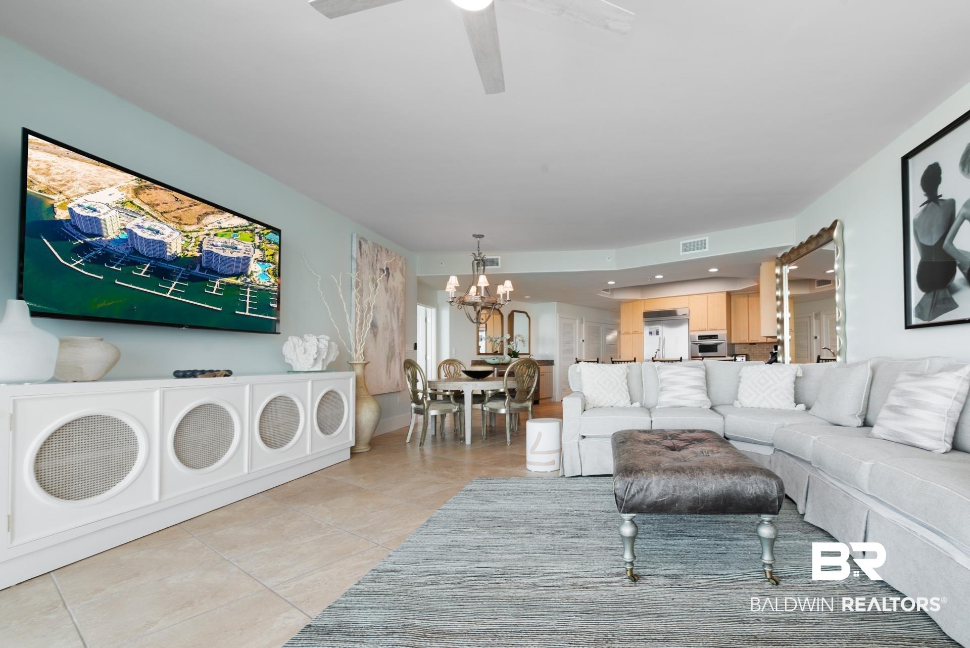 Image 3: Living area with suspended lighting, ceiling fan, and light tile patterned floors