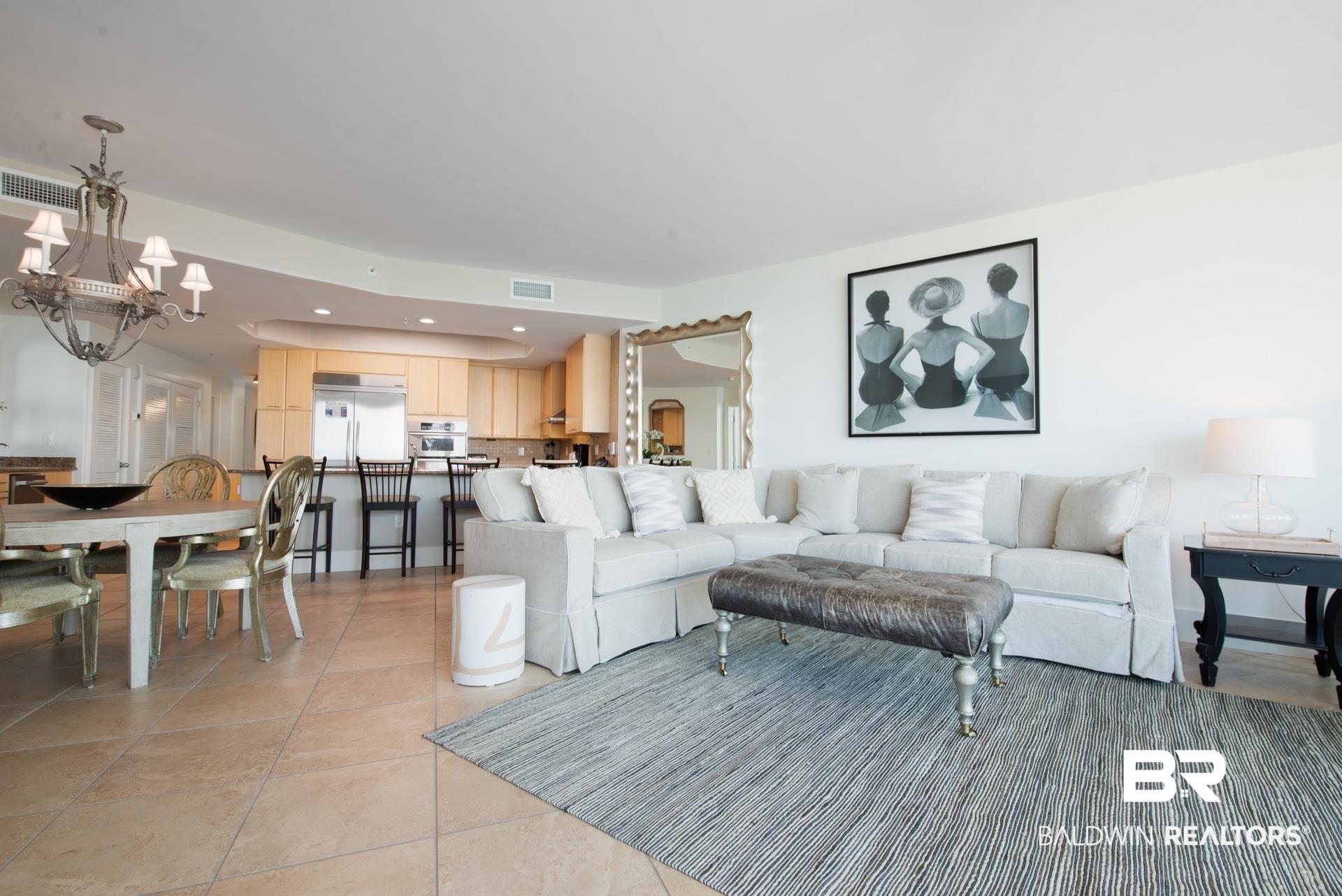Image 4: Living area with a chandelier and light tile patterned floors