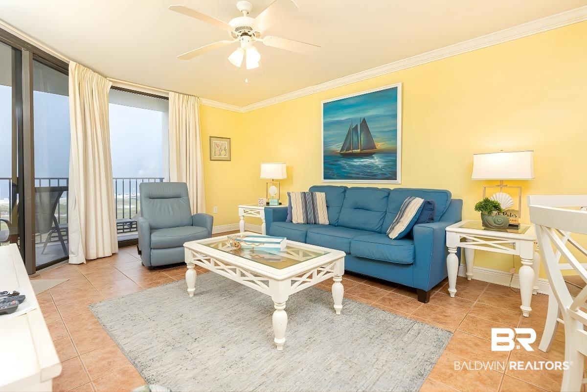 Image 3: Living area featuring a ceiling fan, crown molding, floor to ceiling windows, and light tile patterned floors