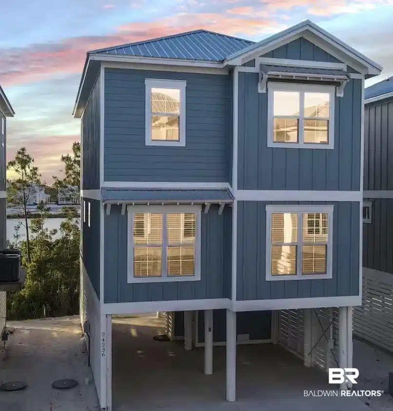 Image 1: Two-story coastal-style residence featuring blue siding and white trim