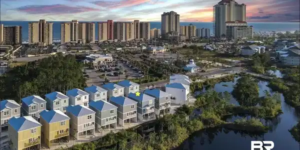 Image 3: Aerial perspective showcasing a row of elevated properties with light-colored siding and white roofs