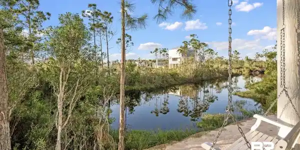 Image 4: Waterfront setting featuring a natural landscape and a white porch swing