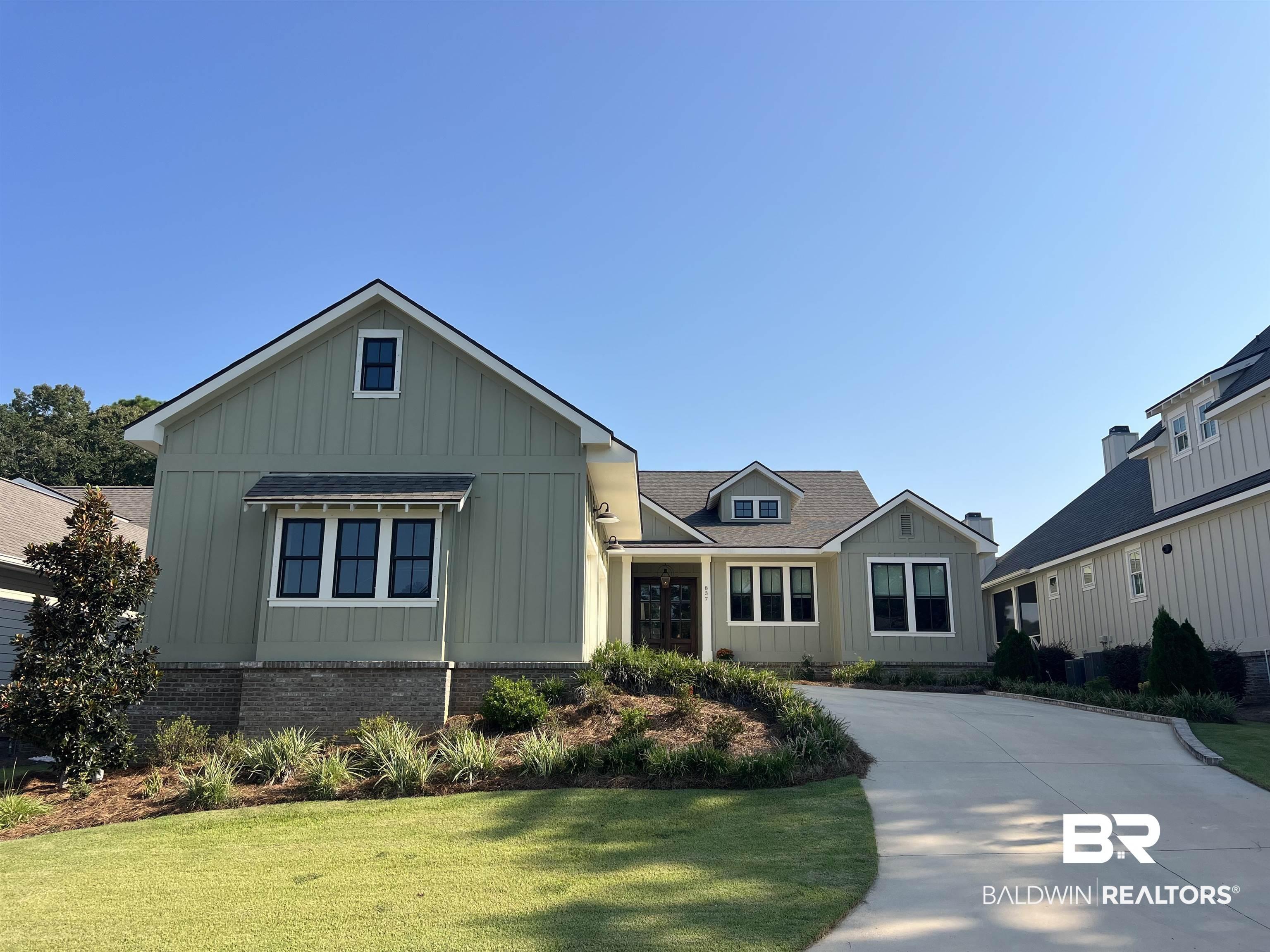 Image 1: View of front of home featuring board and batten siding, a front yard, driveway, and a shingled roof