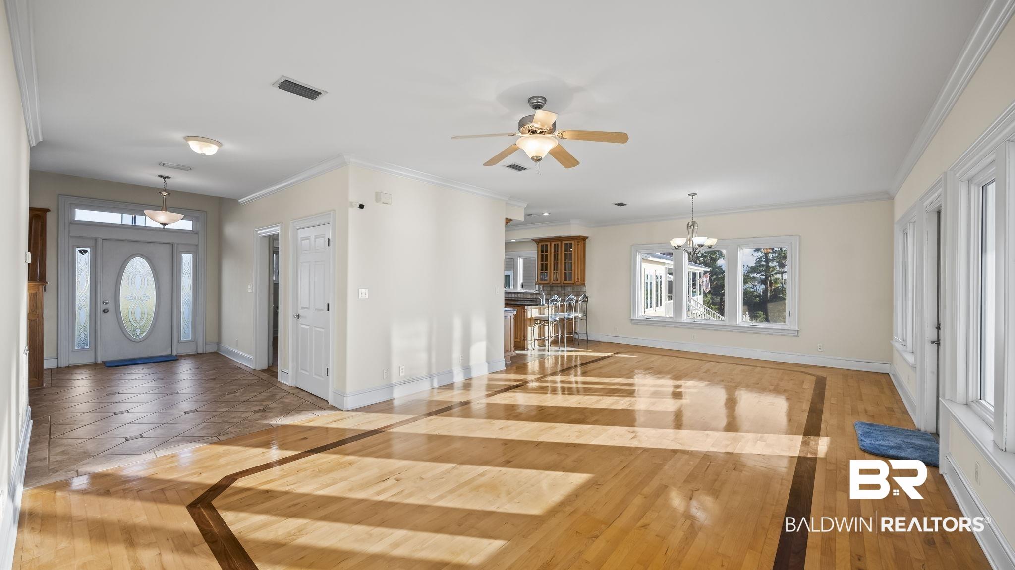 Image 3: Foyer entrance with light wood-style floors, ornamental molding, a chandelier, and a ceiling fan
