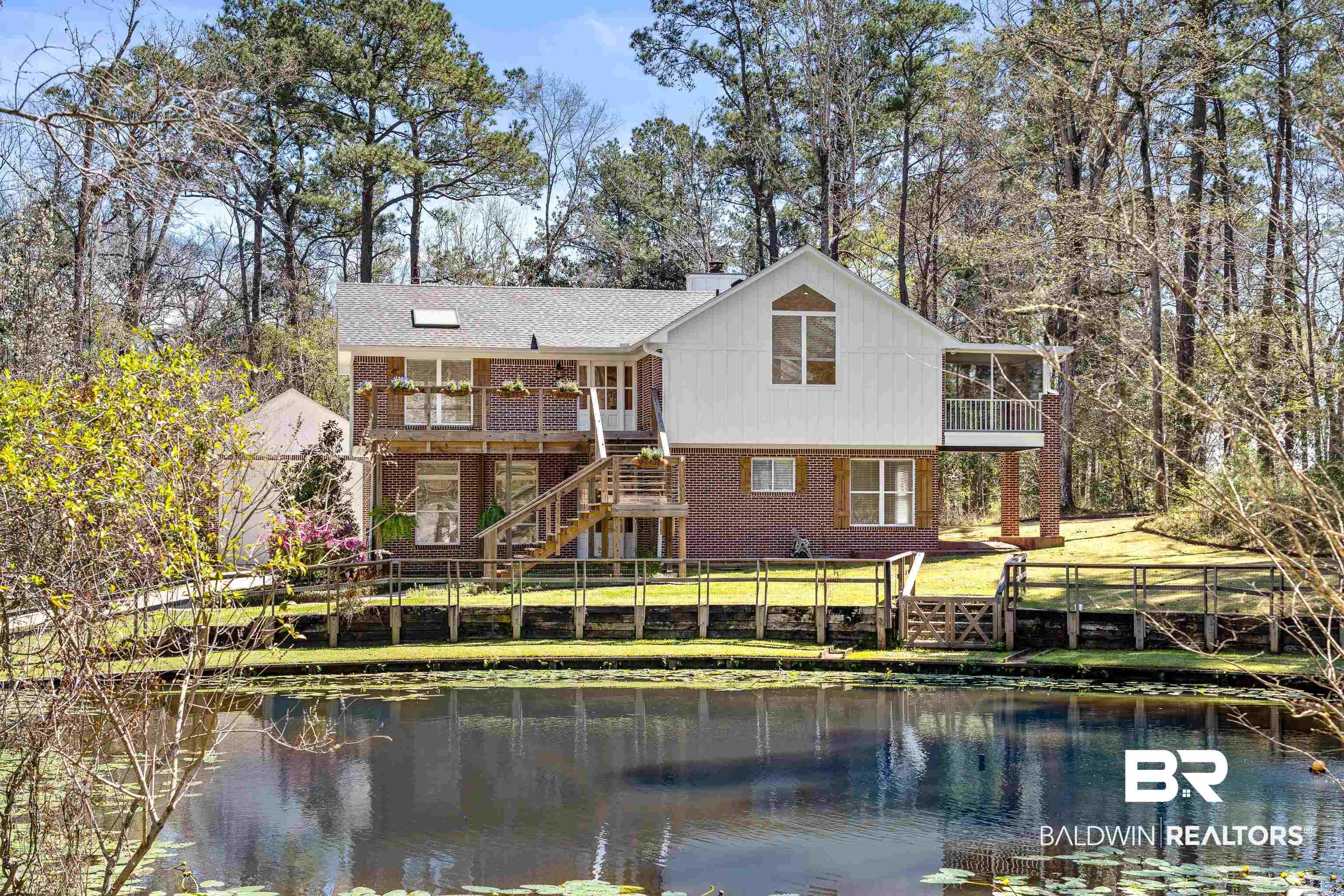 Image 1: Rear view of house with stairway, a water view, and a balcony