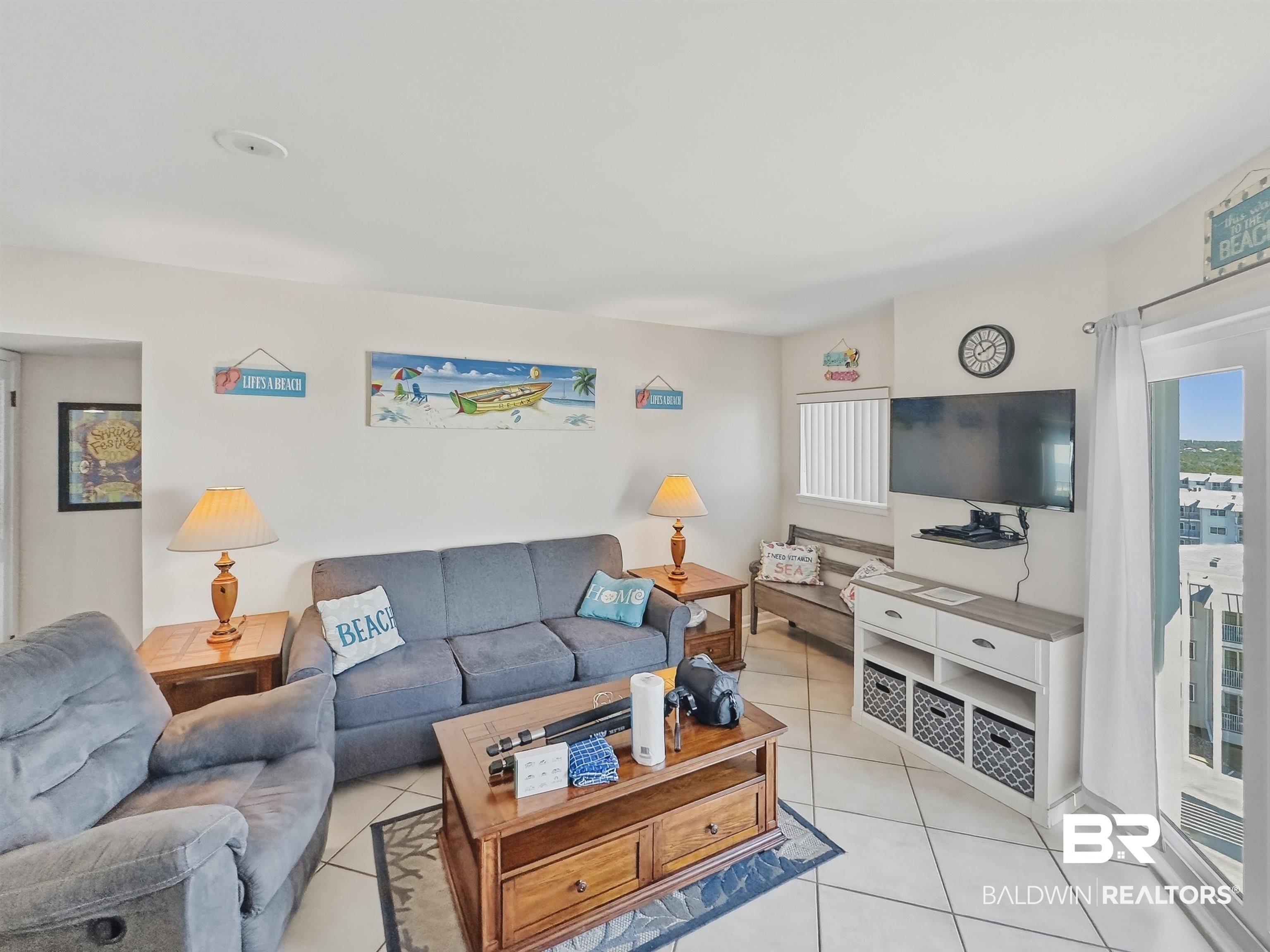 Image 4: Living area with plenty of natural light and light tile patterned flooring
