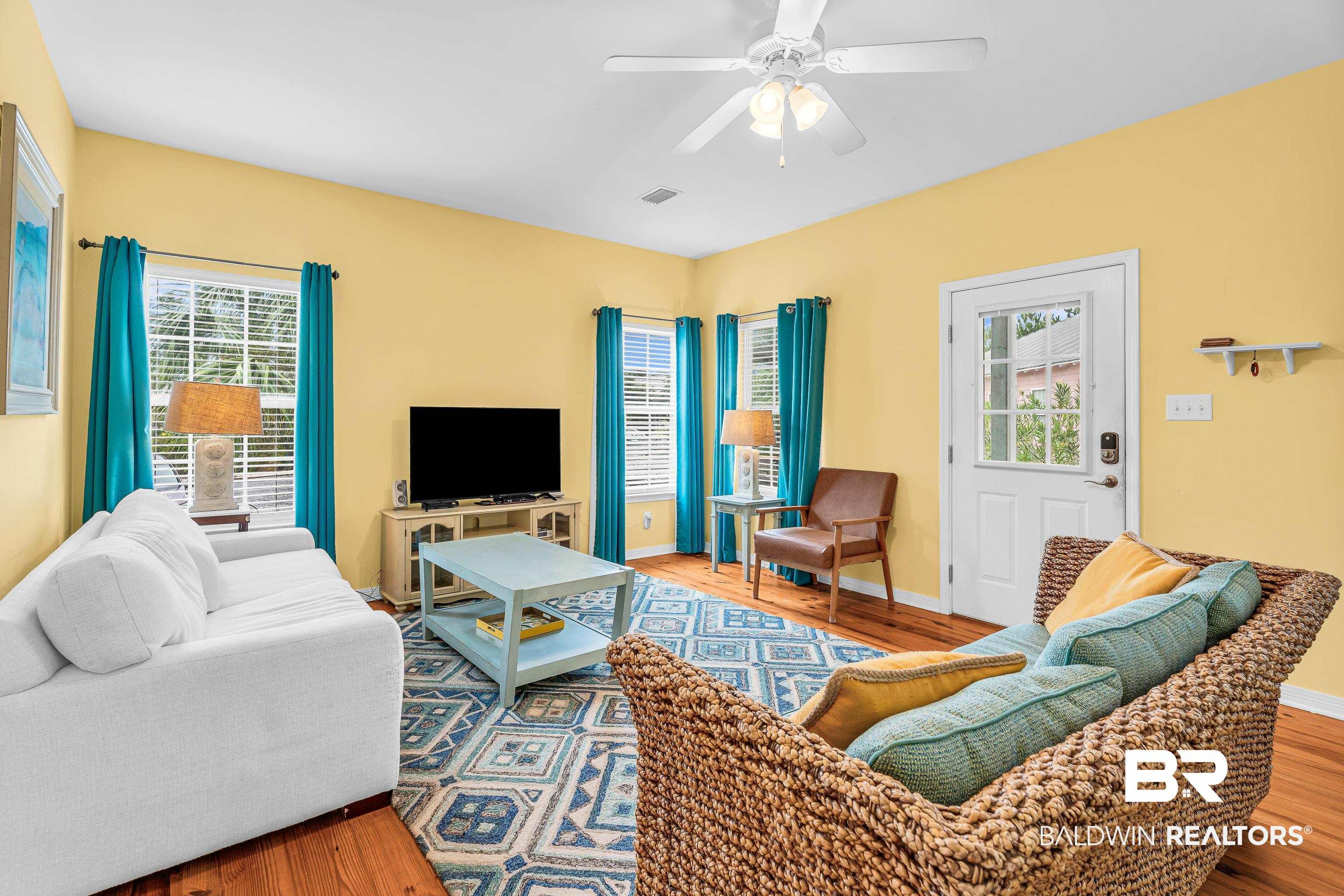 Image 4: Living space featuring wood-finish flooring, a ceiling fan, and multiple windows