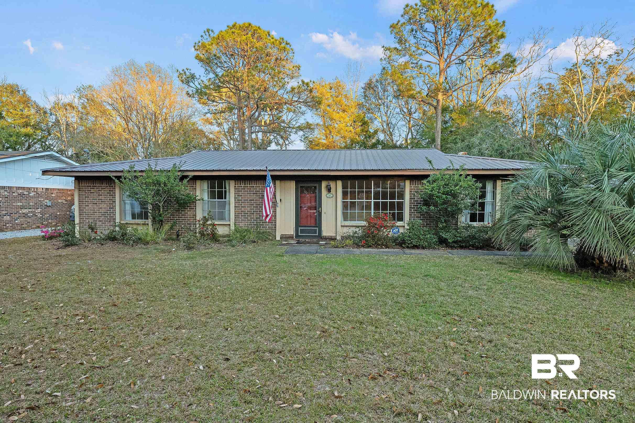 Image 1: Ranch-style home featuring brick siding and a front lawn