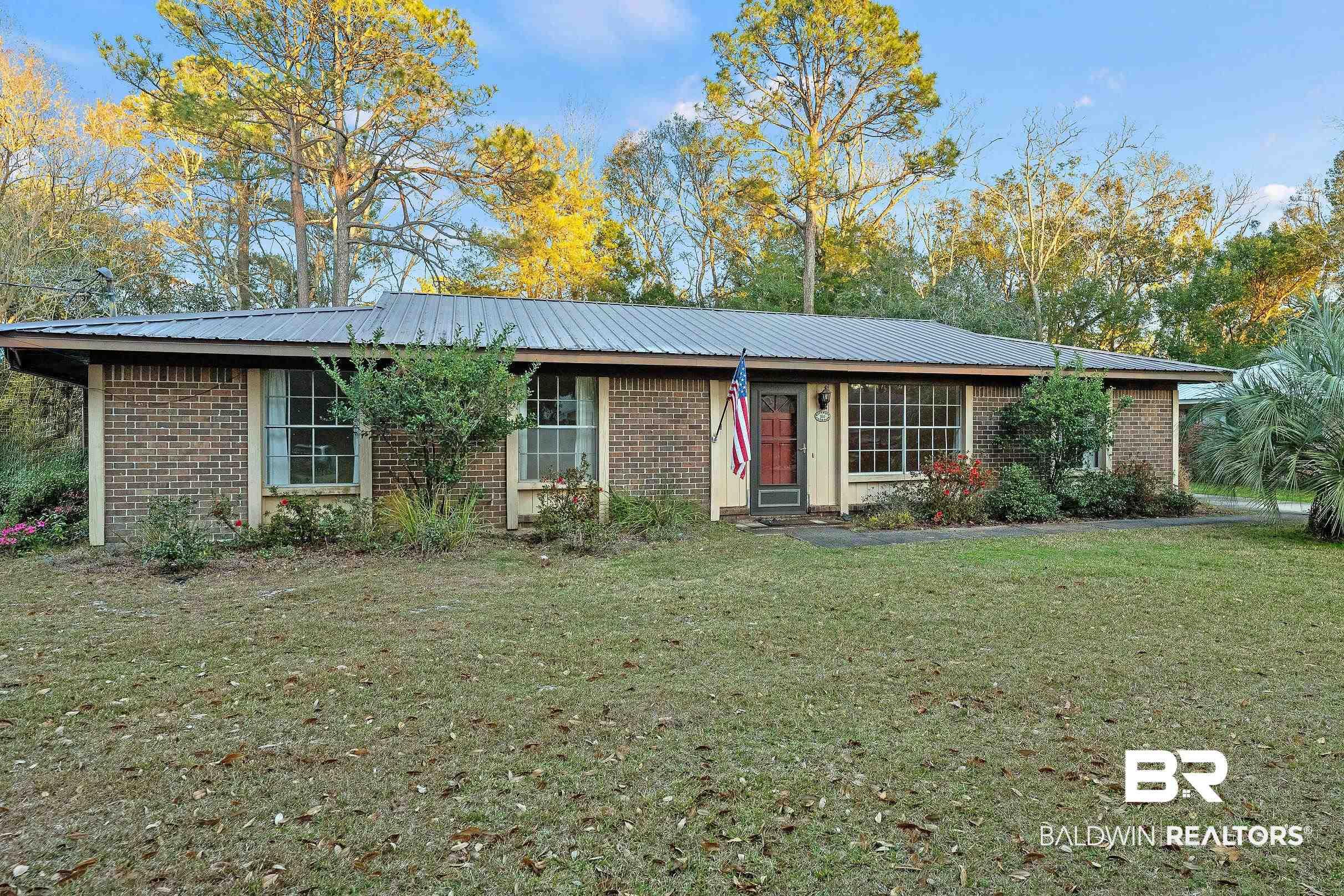 Image 2: Ranch-style house with brick siding, a front lawn, and a metal roof