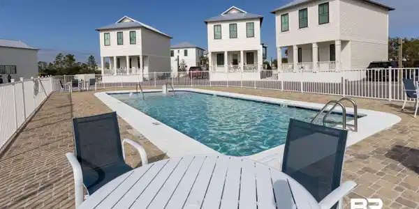 Image 2: Community pool featuring a patio and outdoor dining space