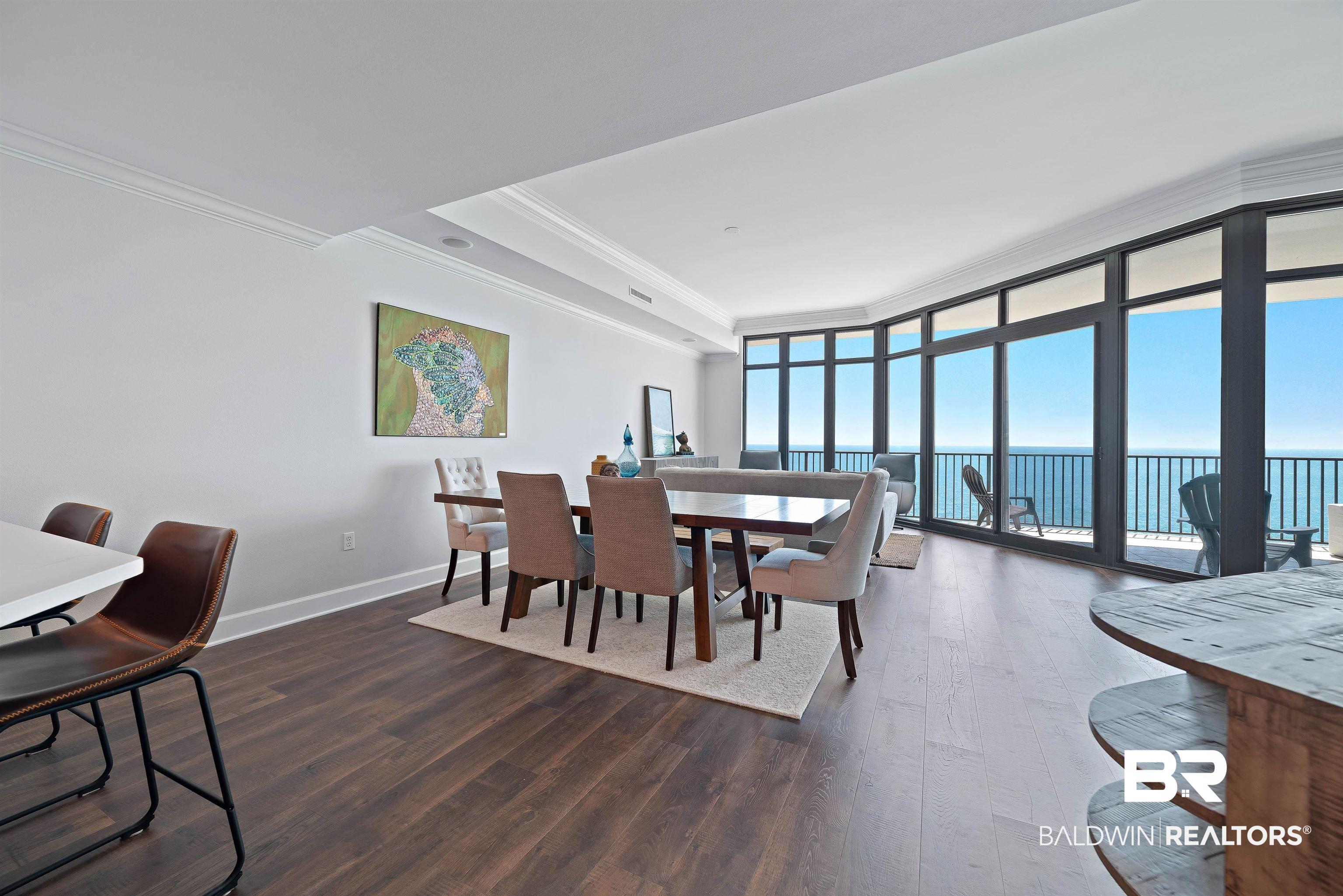 Image 3: Dining space featuring ornamental molding, dark wood-type flooring, and floor to ceiling windows