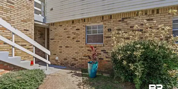 Image 2: Brick exterior featuring horizontal vinyl siding and concrete stairs with white railings