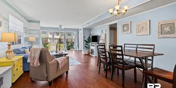 Image 3: Open-concept living and dining area featuring wood-finish flooring throughout