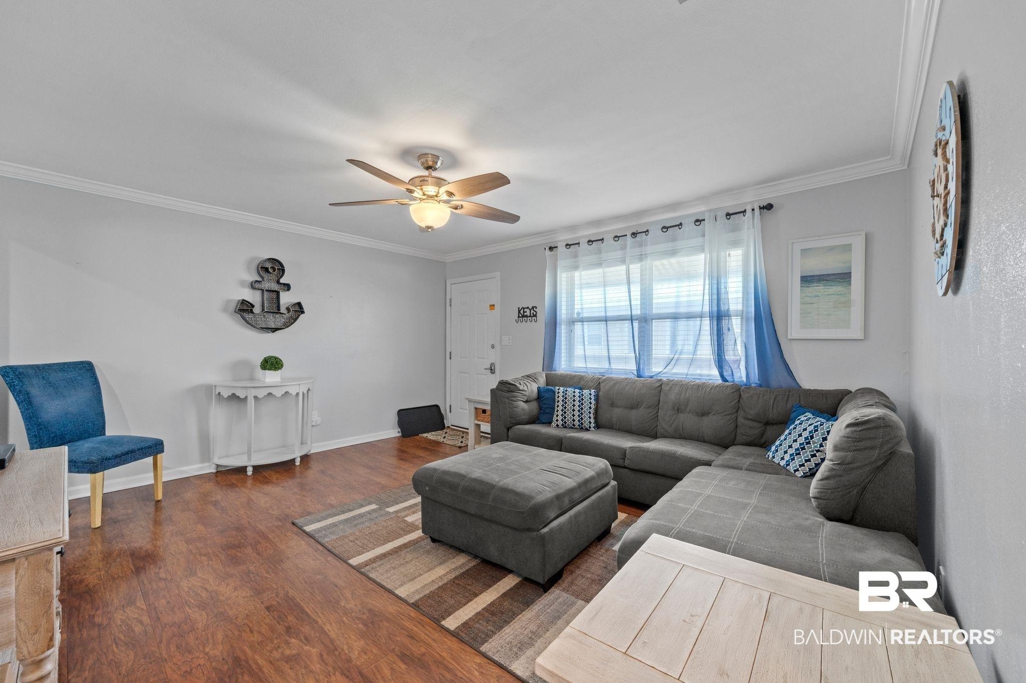 Image 4: Living room with baseboards, a ceiling fan, crown molding, and wood finished floors