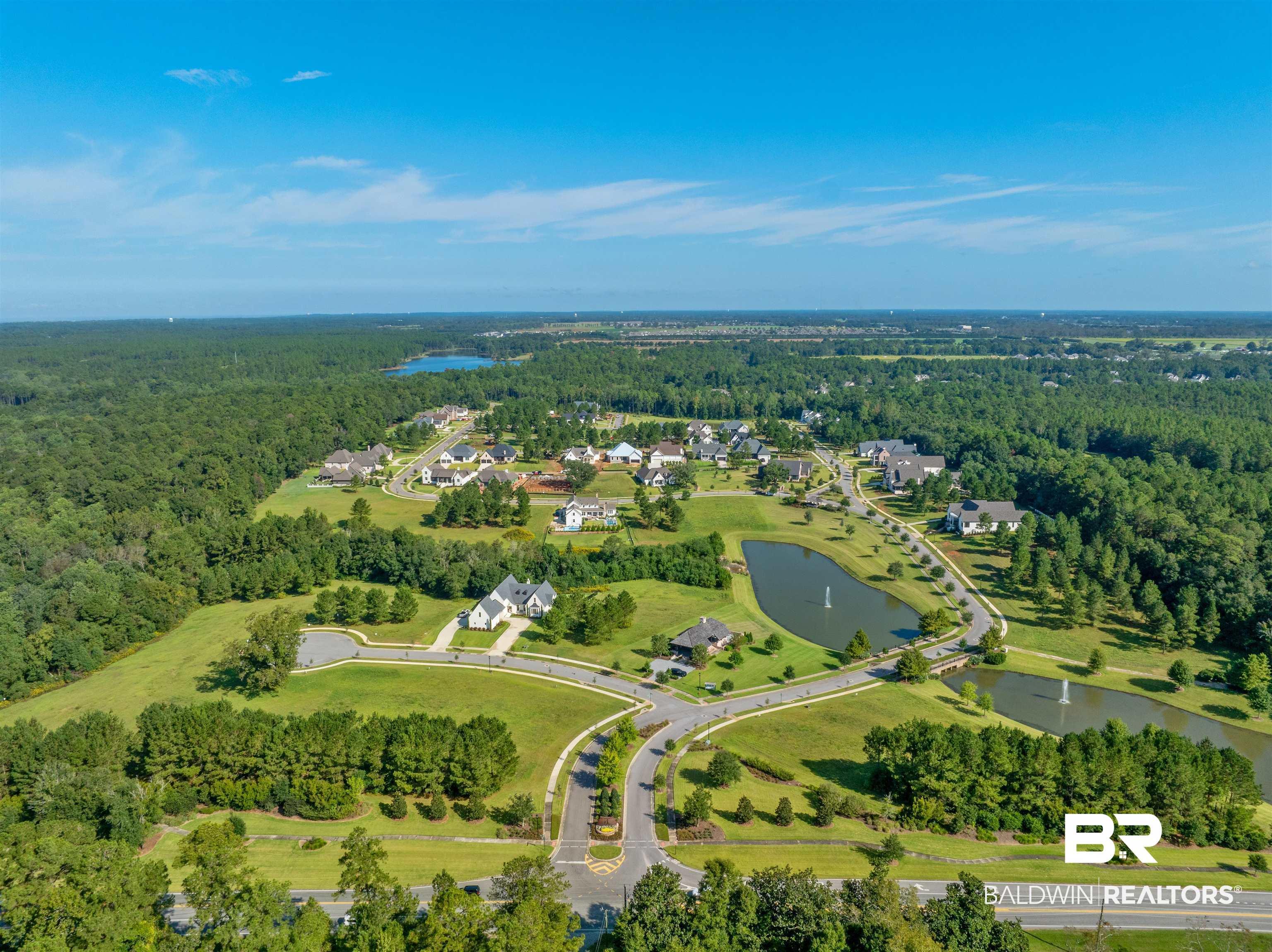 Image 3: Aerial view of property and surrounding area featuring a nearby body of water and a heavily wooded area
