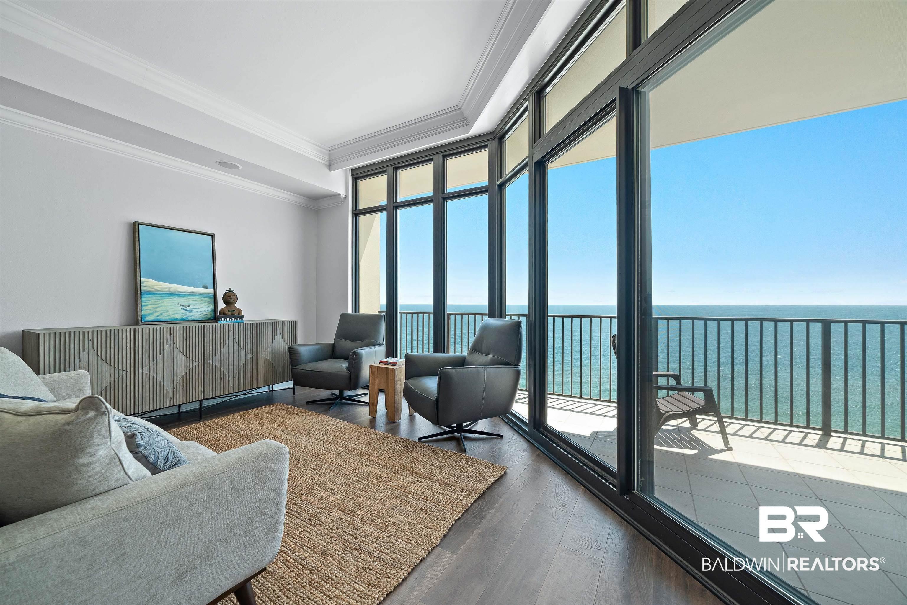 Image 4: Living room with a water view, crown molding, and wood finished floors