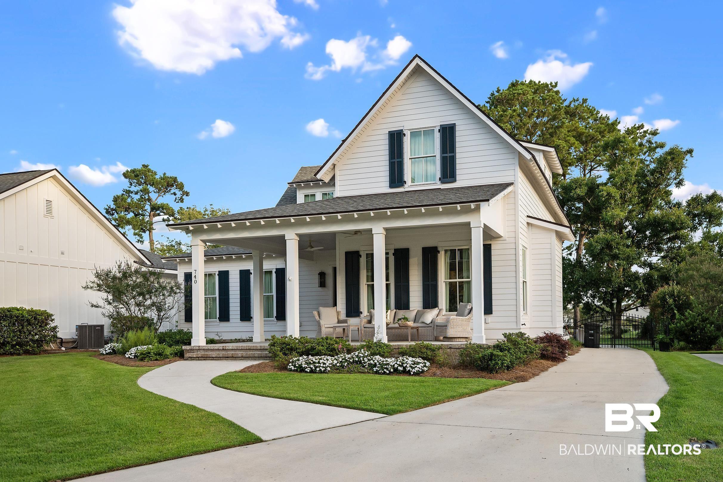 Image 2: White clapboard exterior with a covered front porch featuring square columns