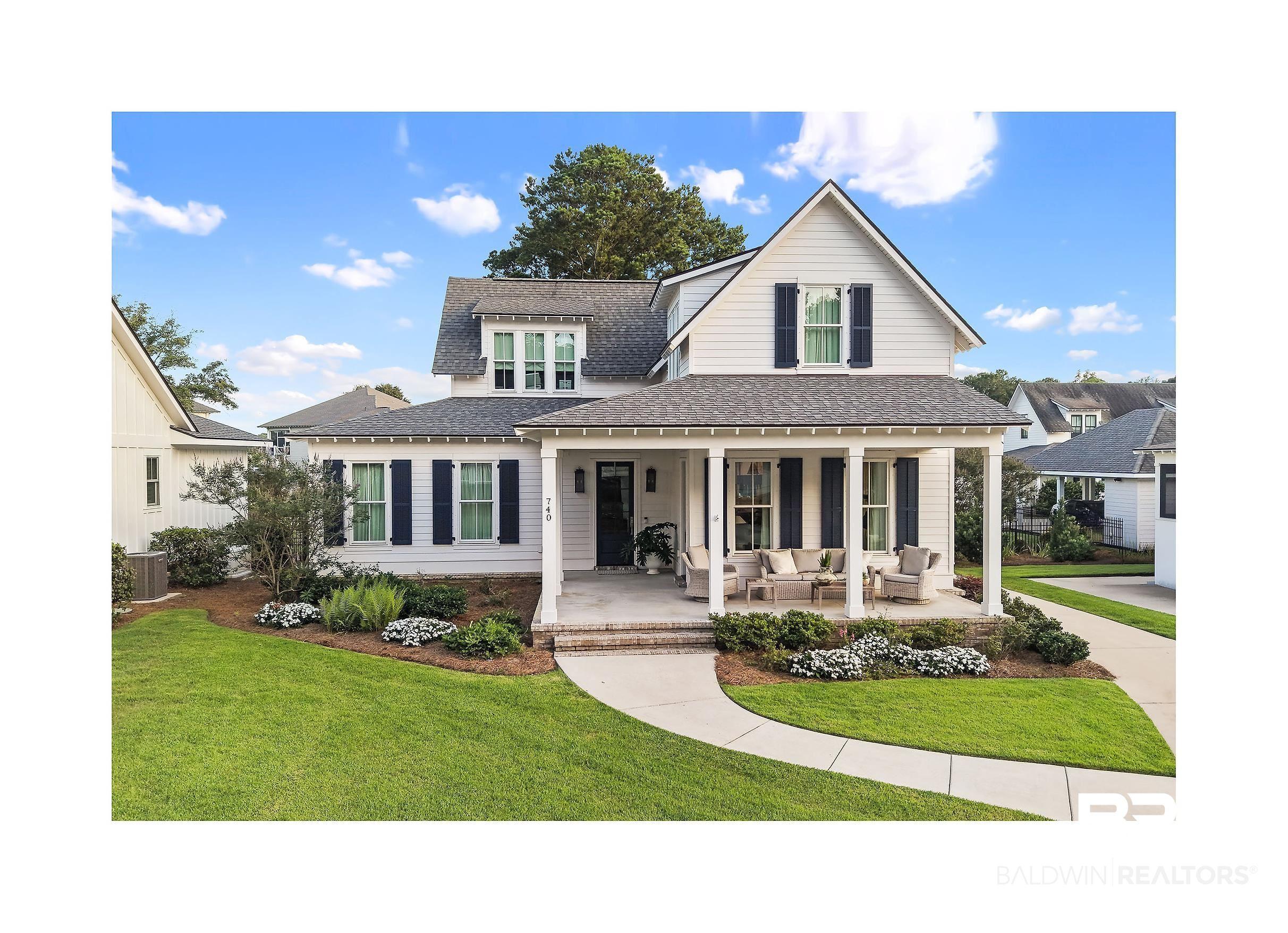 Image 4: White siding exterior with a dark shingle roof and black window shutters