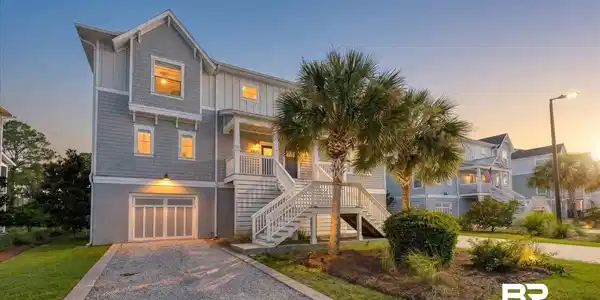 Image 3: Three-story coastal-style residence featuring light blue siding with white trim accents and a gable roofline