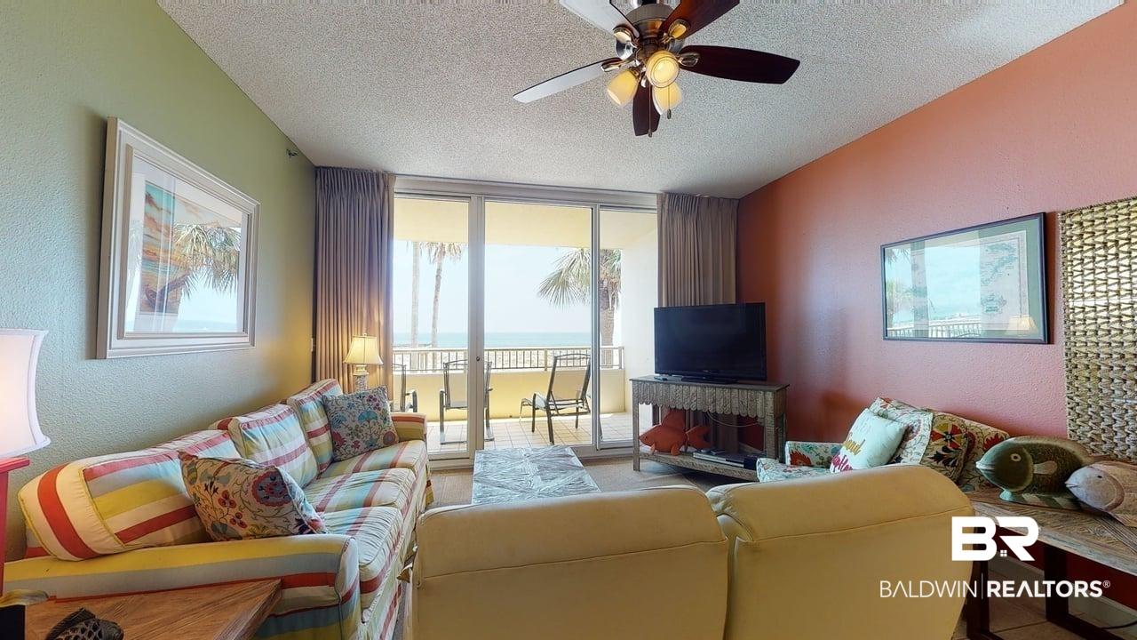 Image 2: Living area with a textured wall, a textured ceiling, ceiling fan, and expansive windows