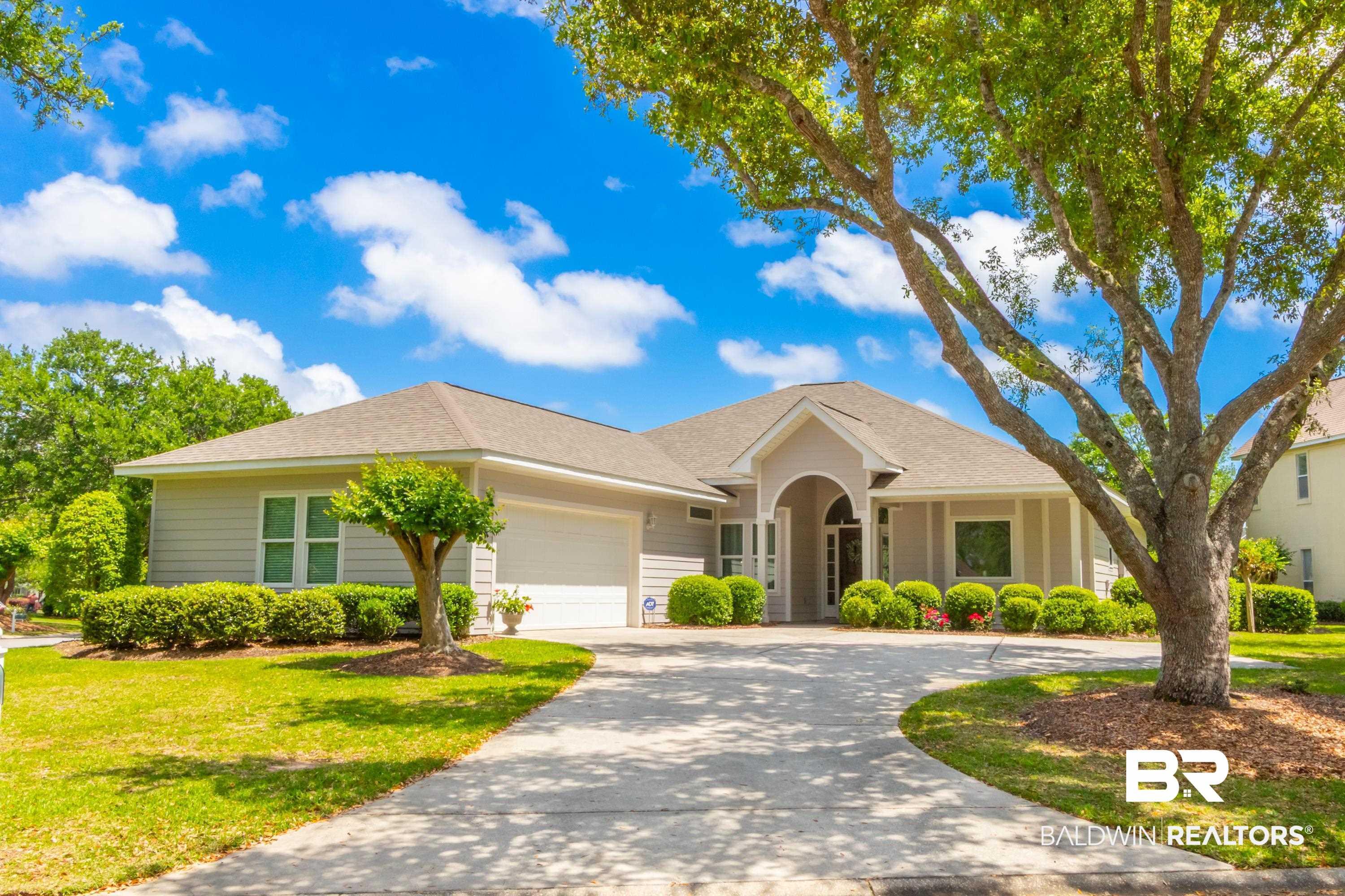 Image 2: Ranch-style house with a shingled roof, an attached garage, curved driveway, and a front yard