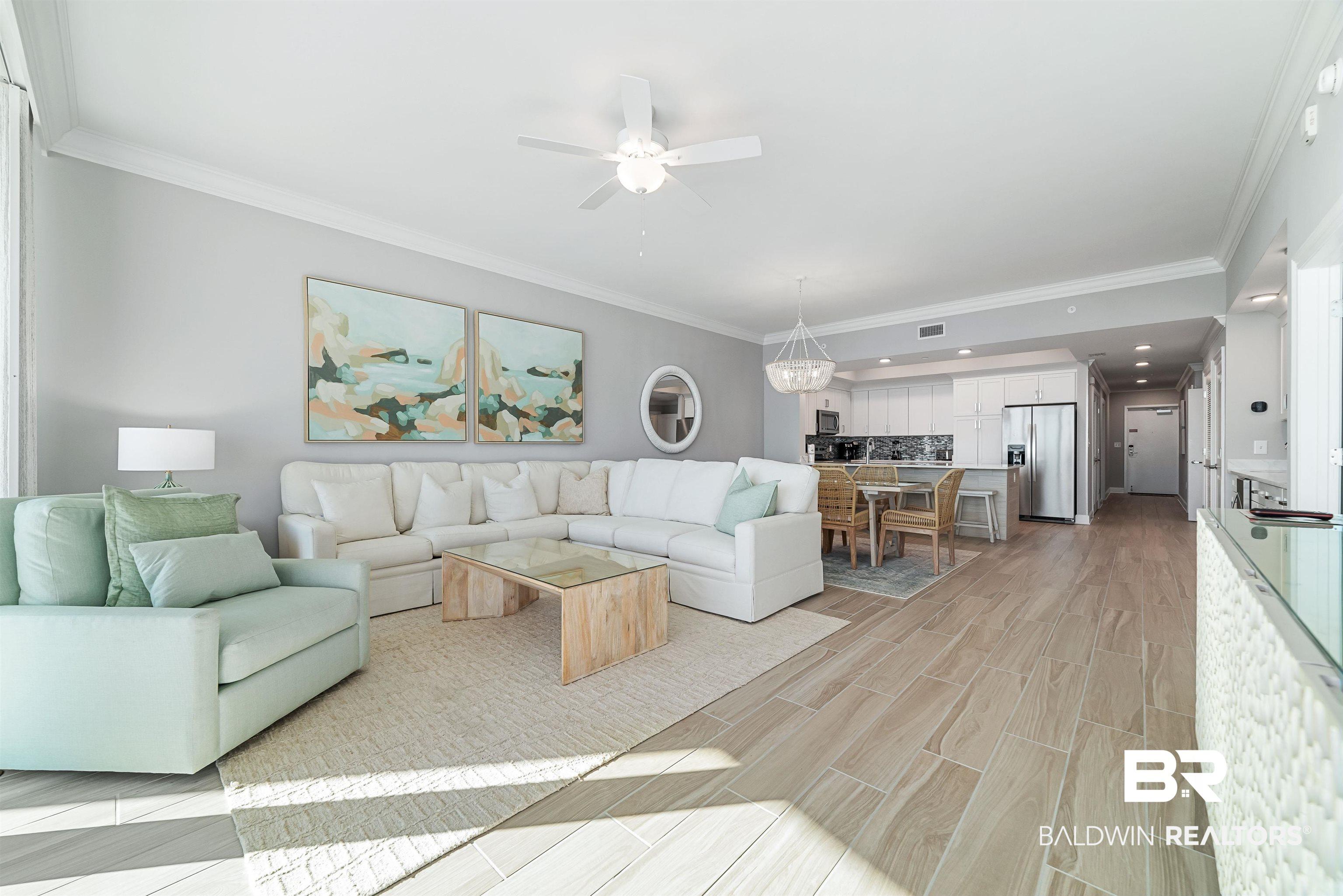 Image 2: Living room featuring crown molding, wood tiled floors, and a ceiling fan