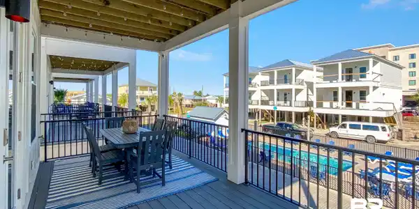 Image 3: Wooden deck with outdoor dining area and a community pool