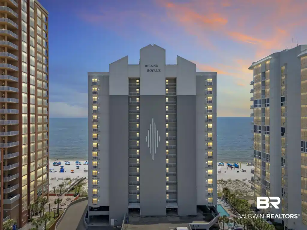 Image 1: Beachfront high-rise building featuring multiple balconies, a ground-level swimming pool, and direct access to a white sand beach with ocean frontage
