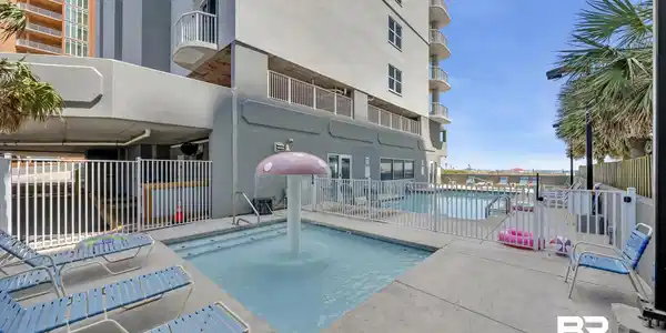 Image 4: Outdoor pool area featuring a mushroom-shaped water feature, concrete decking, and multiple lounge chairs