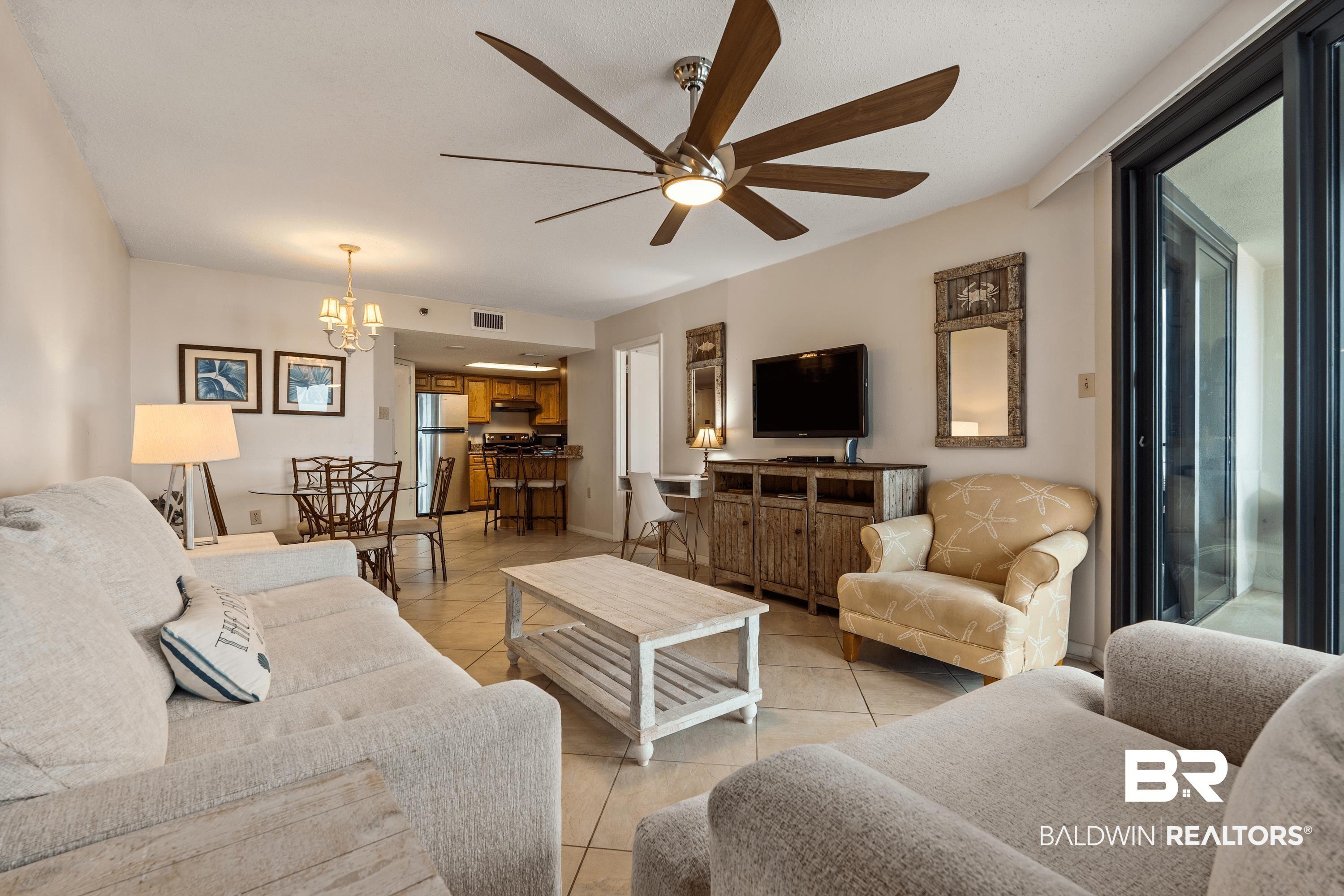 Image 4: Open-concept living space with tile flooring, a multi-blade ceiling fan, and a light-toned color palette