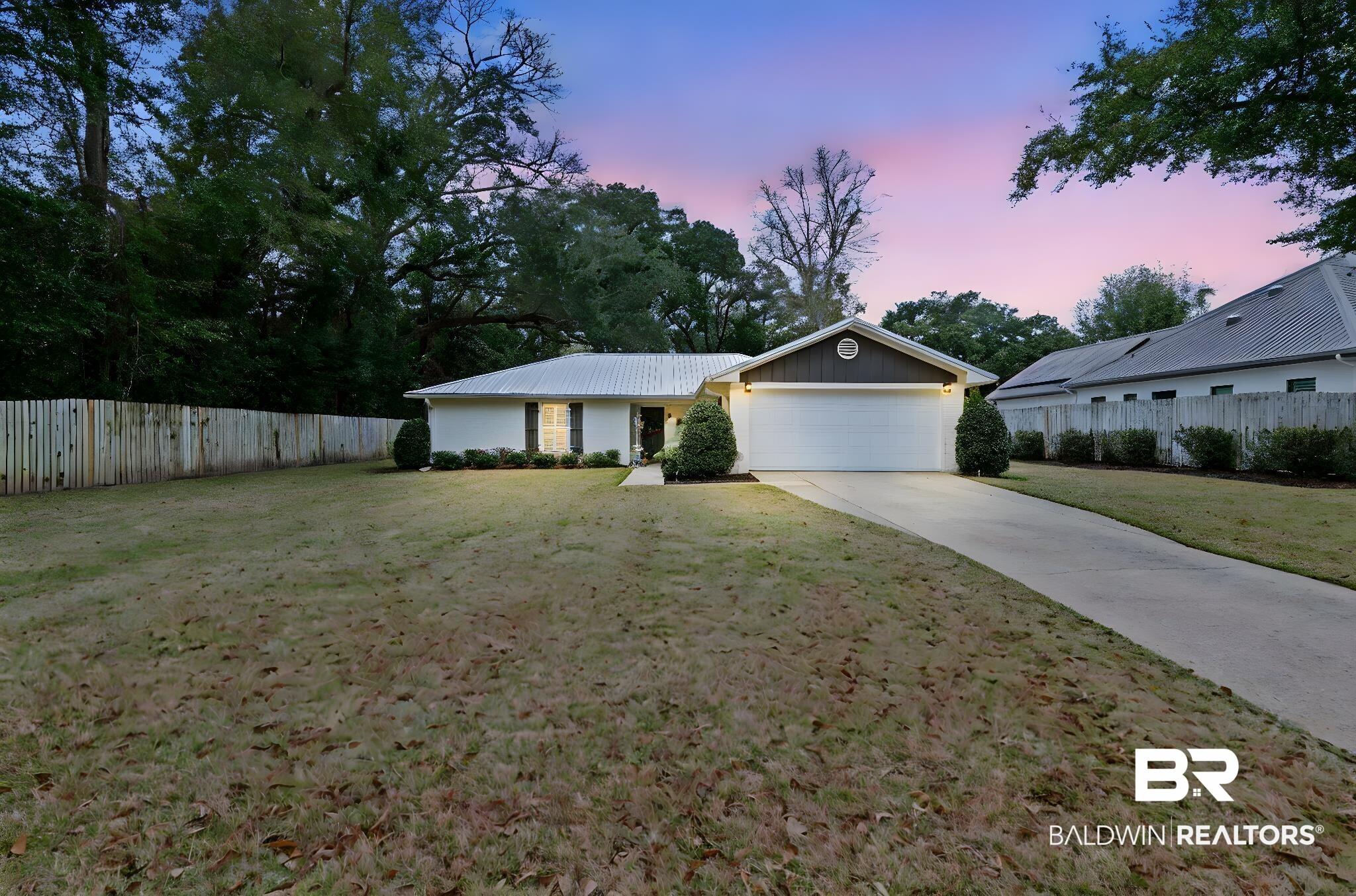 Image 1: Ranch-style home featuring driveway and an attached garage