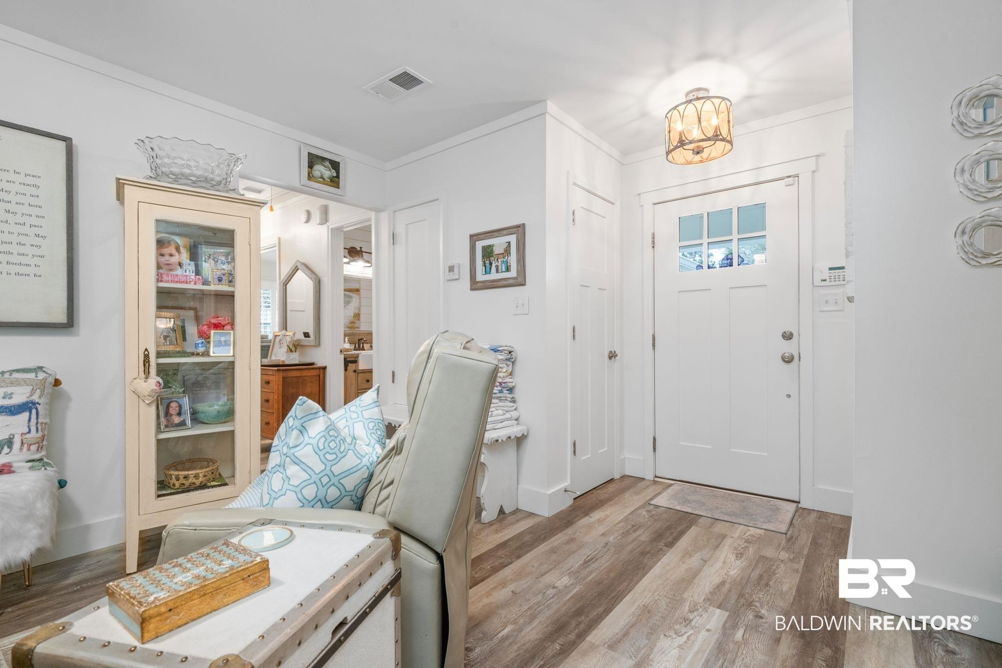 Image 3: Entryway featuring light wood finished floors, crown molding, and a chandelier