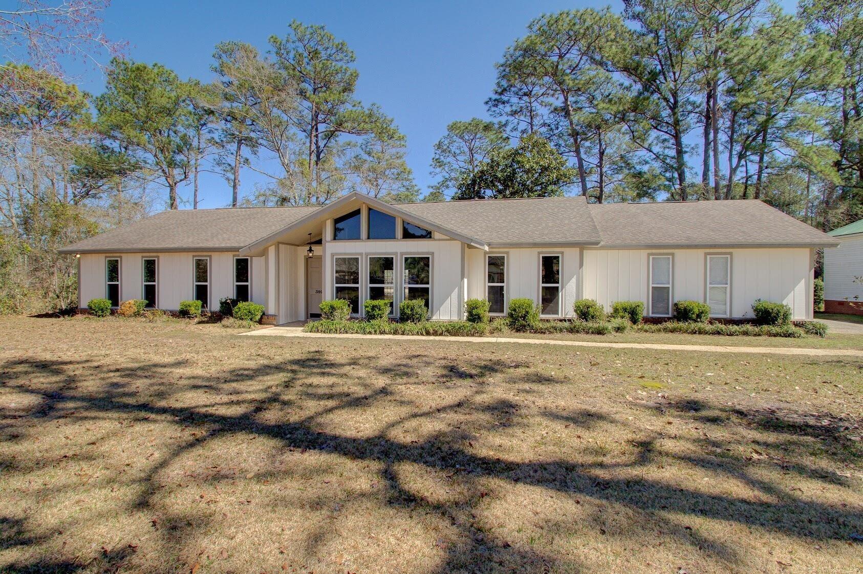 Image 3: View of front facade featuring a shingled roof and a front yard