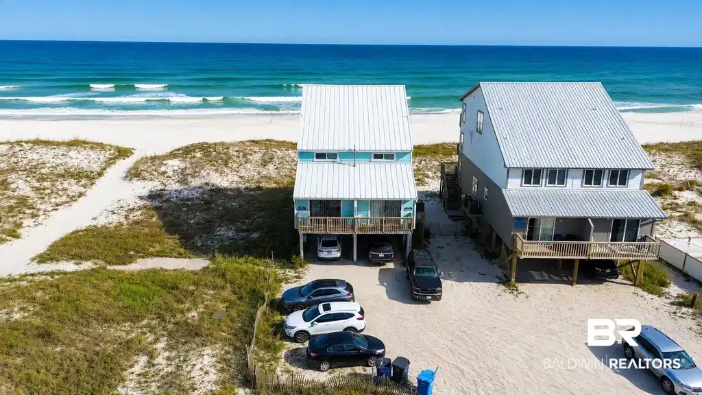 Image 1: Coastal home featuring a carport and dirt driveway