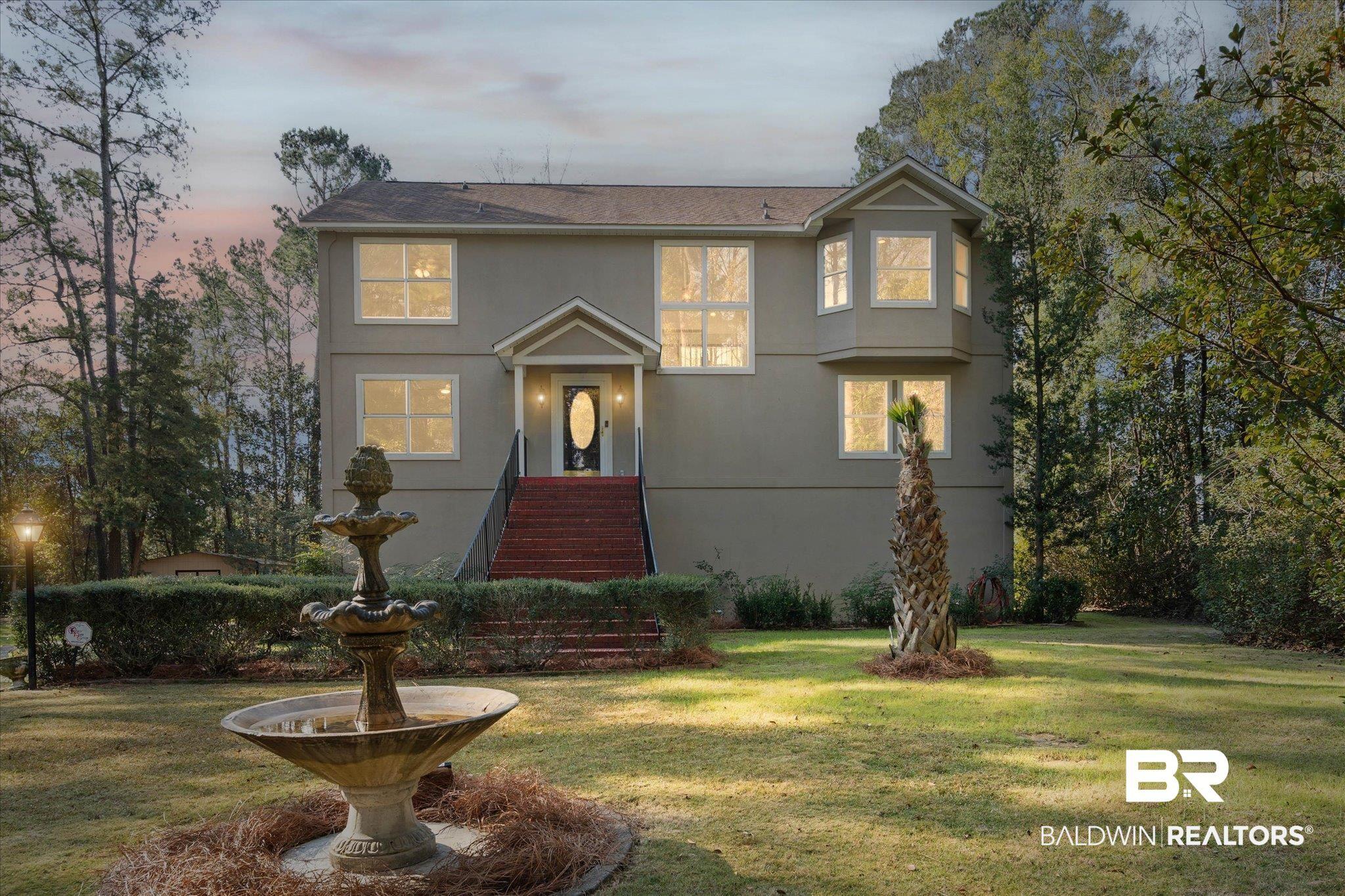 Image 1: Traditional-style house featuring a front yard and stucco siding