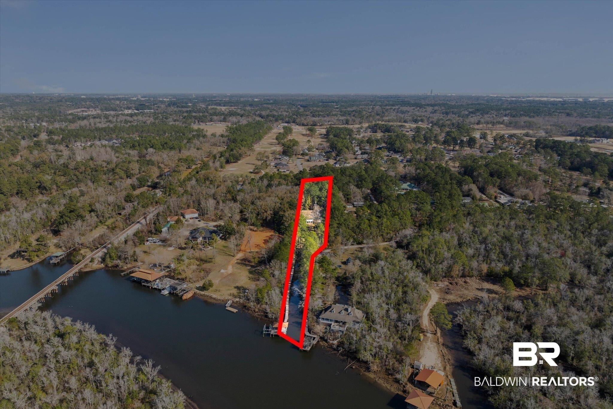 Image 3: Aerial view of property's location with property parcel outlined and a large body of water